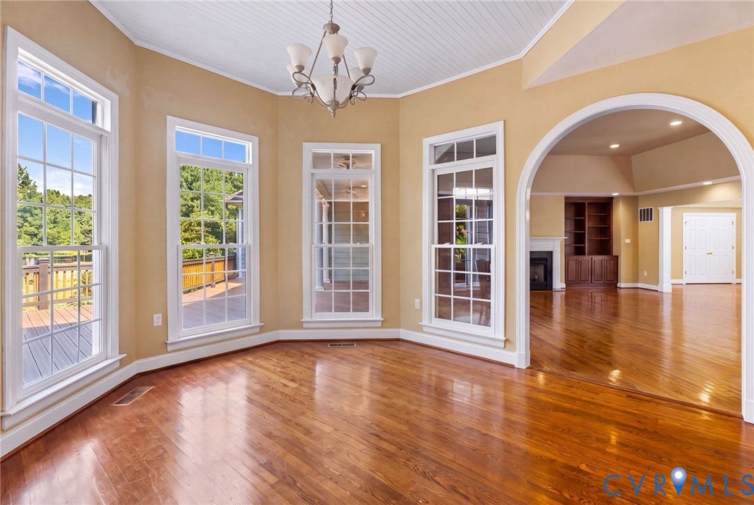 2365 Manakintown Ferry Road, Powhatan, VA 23113 Hardwood flooring, arched doorway, coffered ceiling, multiple windows, and a chandelier