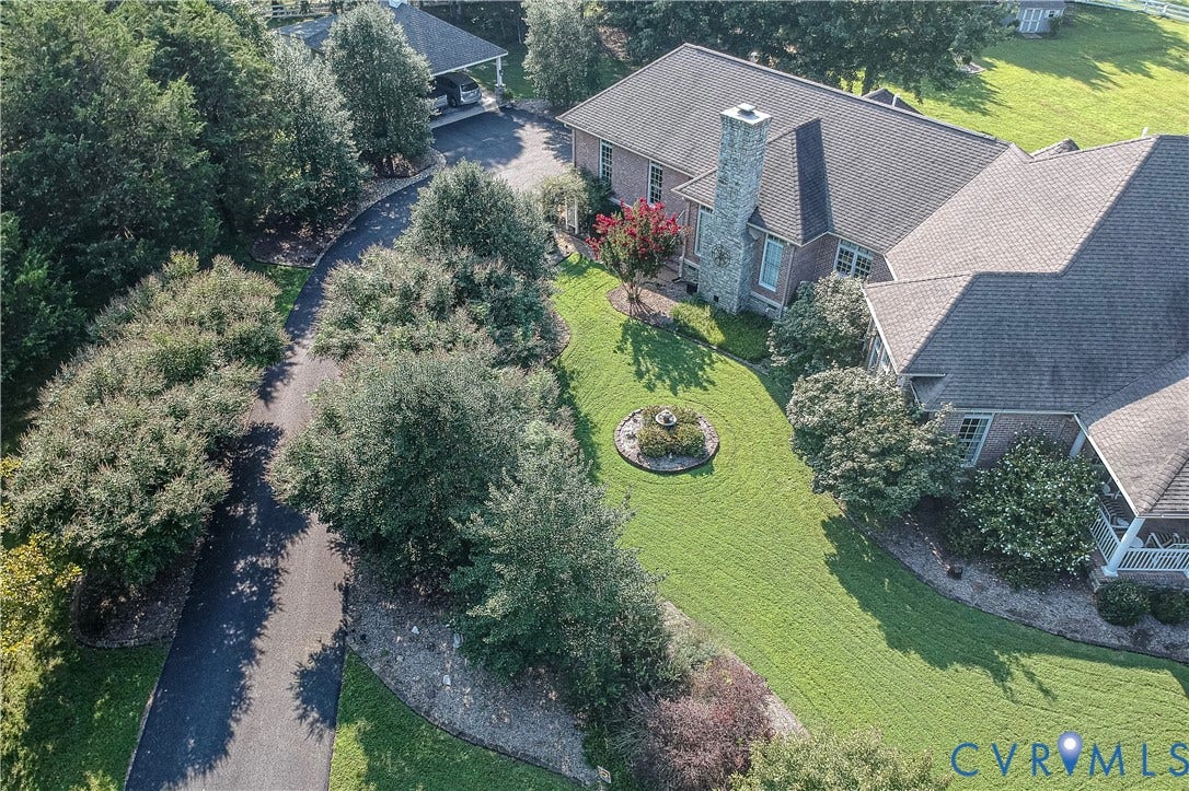 2365 Manakintown Ferry Road, Powhatan, VA 23113 Brick exterior with a stone chimney, extensive green lawn, mature trees, and a paved driveway leading to a covered parking area