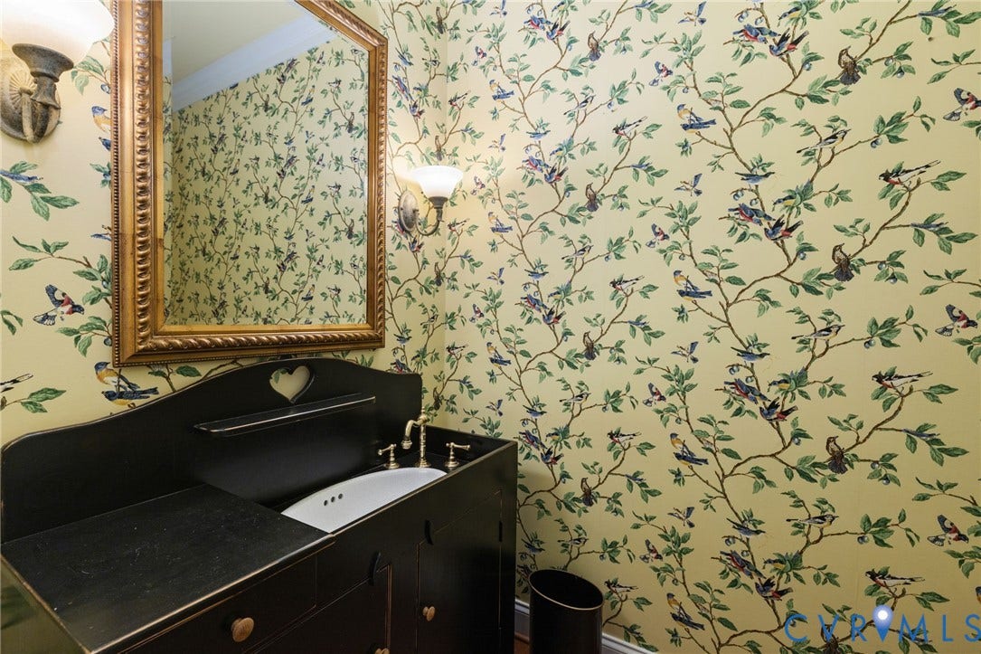 2365 Manakintown Ferry Road, Powhatan, VA 23113 Black vanity with integrated sink, brass-finish faucet, framed mirror, and wall-mounted sconces