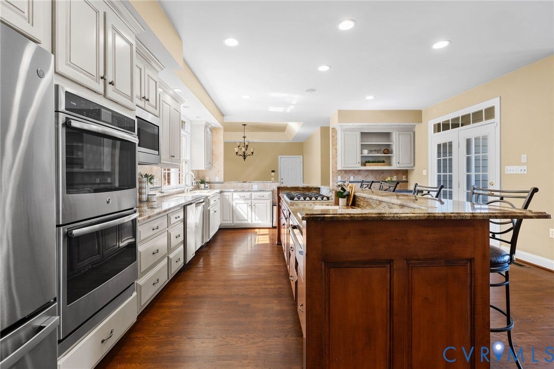 2365 Manakintown Ferry Road, Powhatan, VA 23113 Gourmet kitchen featuring stainless steel appliances, white cabinetry, a large center island with a cooktop, and wood-finish flooring