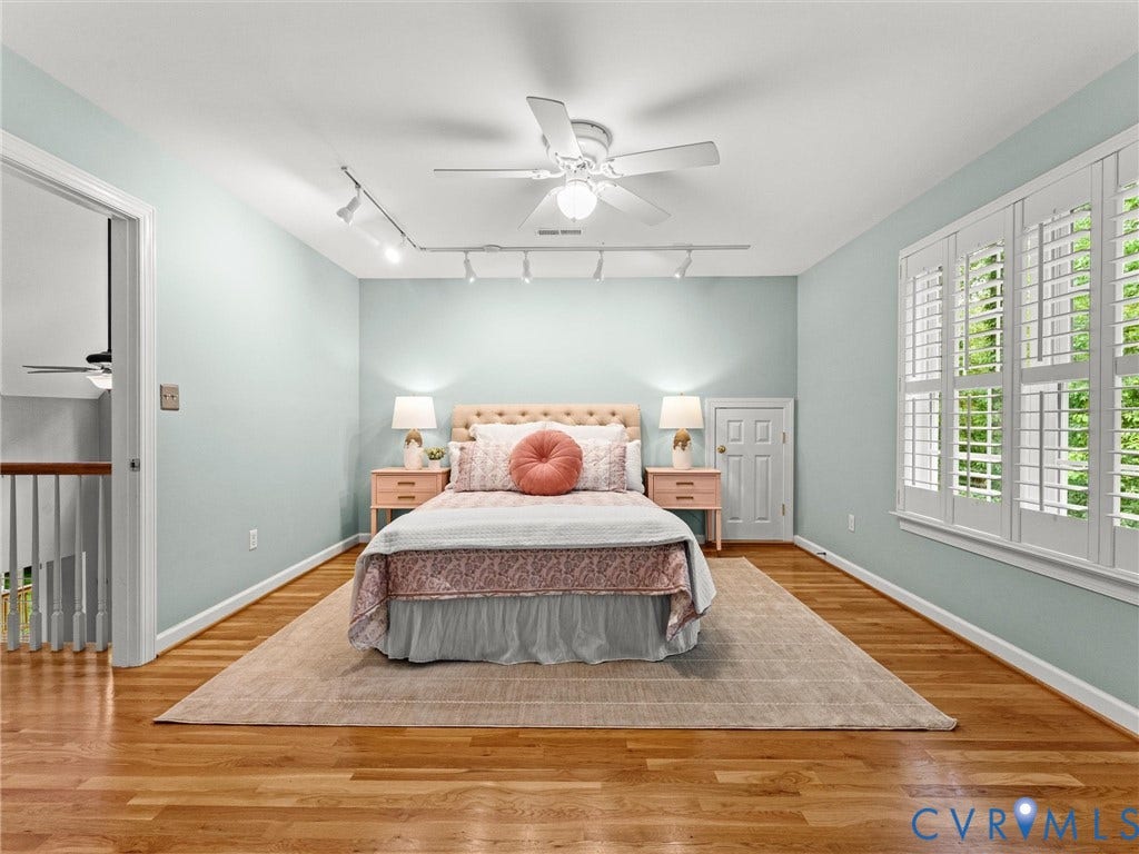 Hardwood flooring, track lighting, ceiling fan, white paneled doors, and white interior shutters