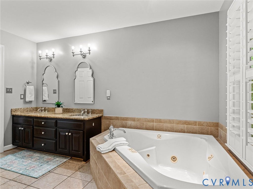 Dual vanity with brown cabinetry and granite-style countertop
