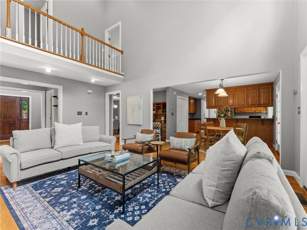 Vaulted ceiling, wood-finish flooring, wood cabinetry, built-in shelving, and a second-level railing