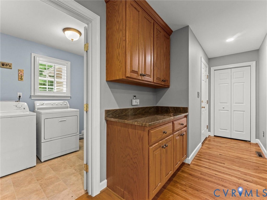 Wood-finish flooring leading to a built-in wood-finish cabinetry with a countertop