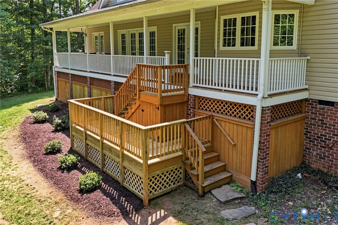 Two-tier wood deck with lattice accents, featuring multiple staircases and a covered porch