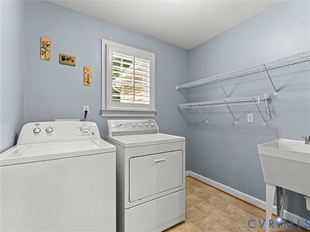 Window with white plantation shutters, utility sink, and wall-mounted wire shelving