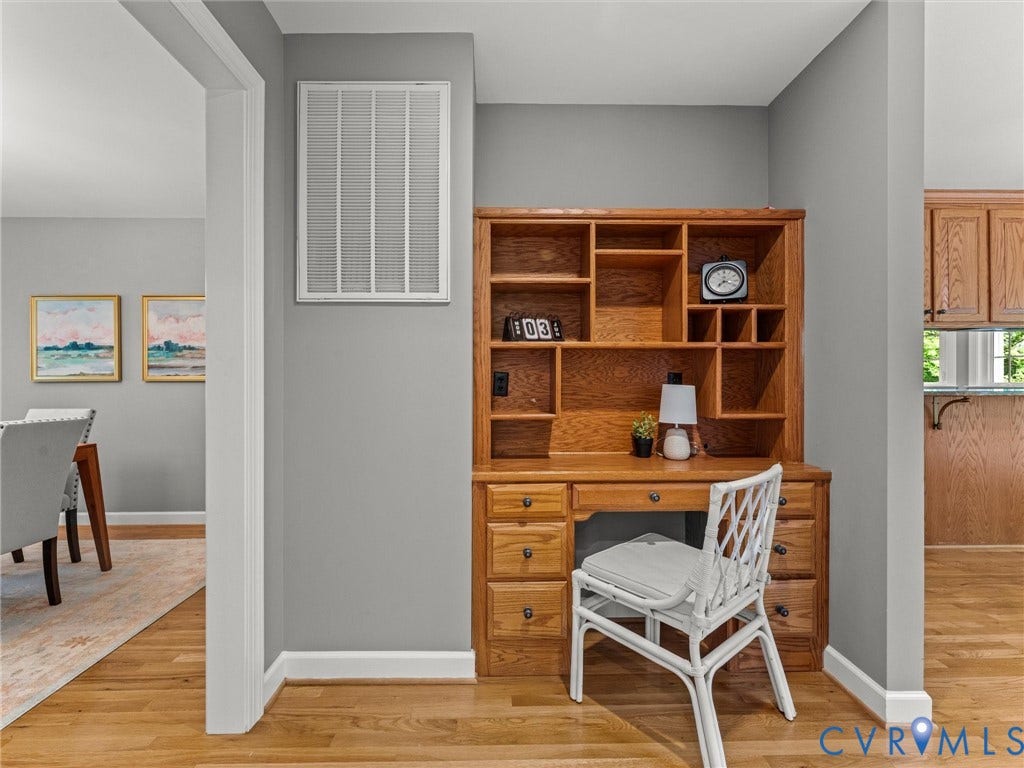 Built-in wood-finish desk with hutch featuring multiple open shelves and drawers