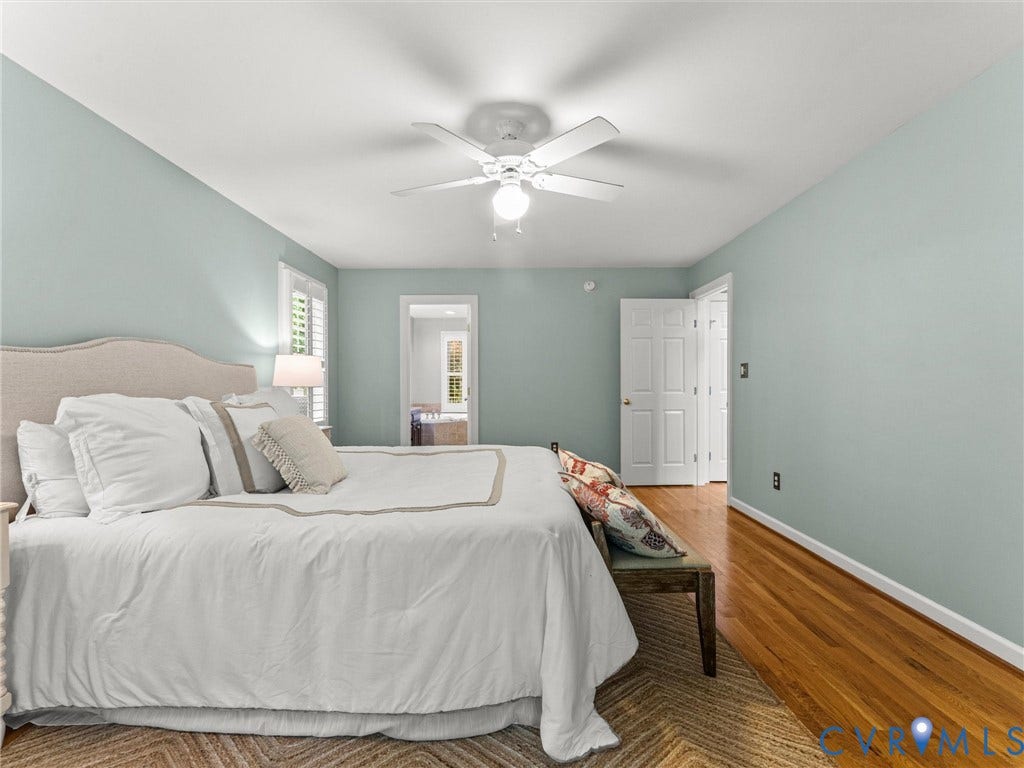 Wood-finish flooring, plantation shutters, ceiling fan with integrated lighting, and a neutral color palette