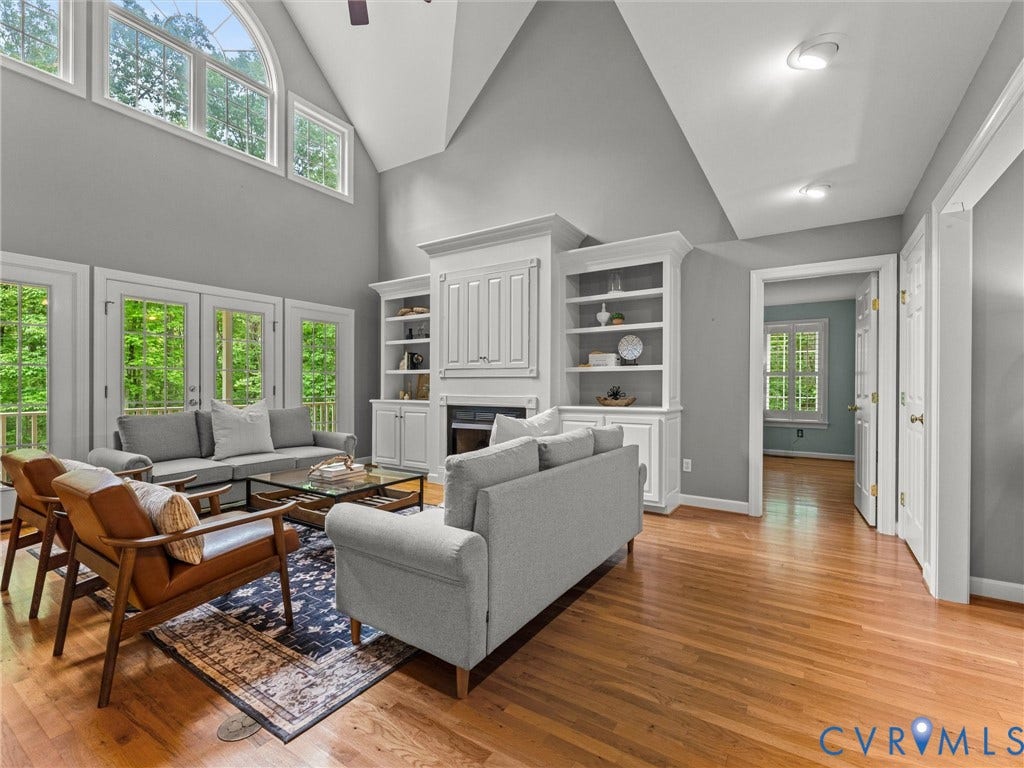Vaulted ceiling with transom windows, wood-finish flooring, built-in shelving, fireplace, and recessed lighting