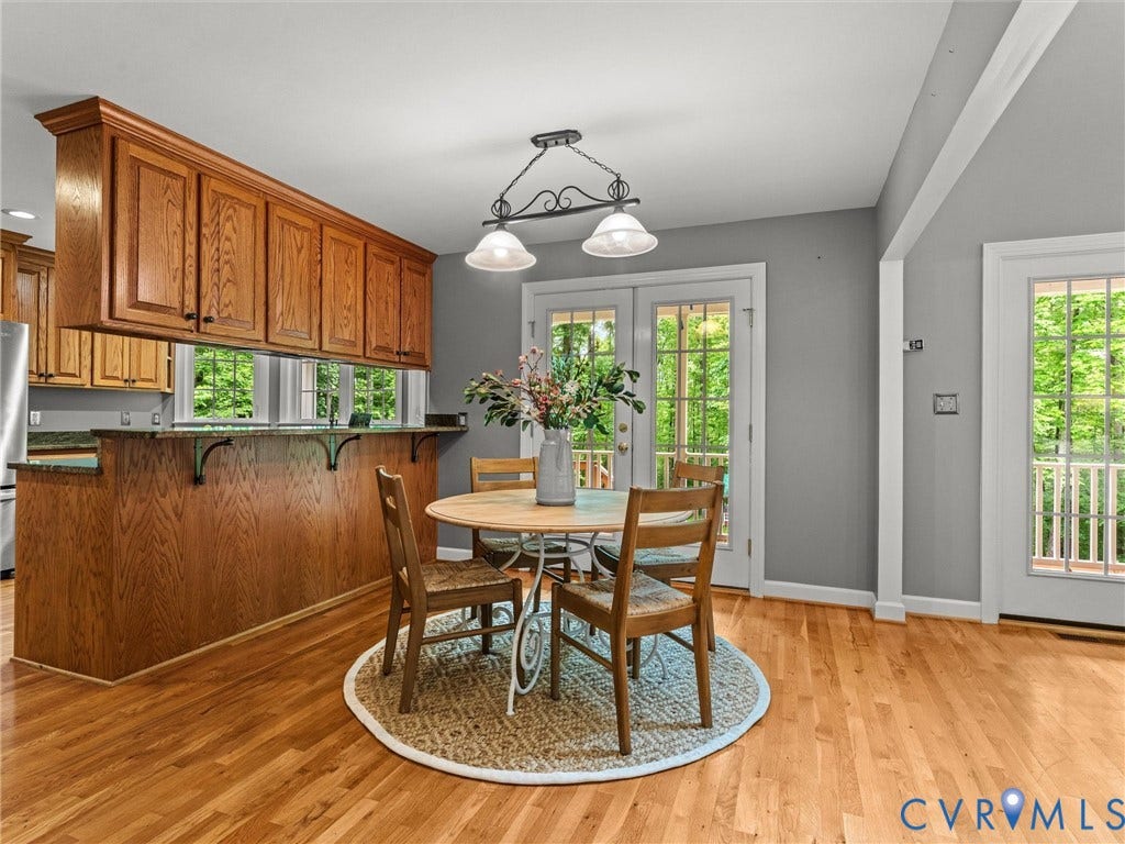 Warm wood cabinetry and countertops anchor this kitchen, featuring ample storage and a window overlooking the outdoor landscape
