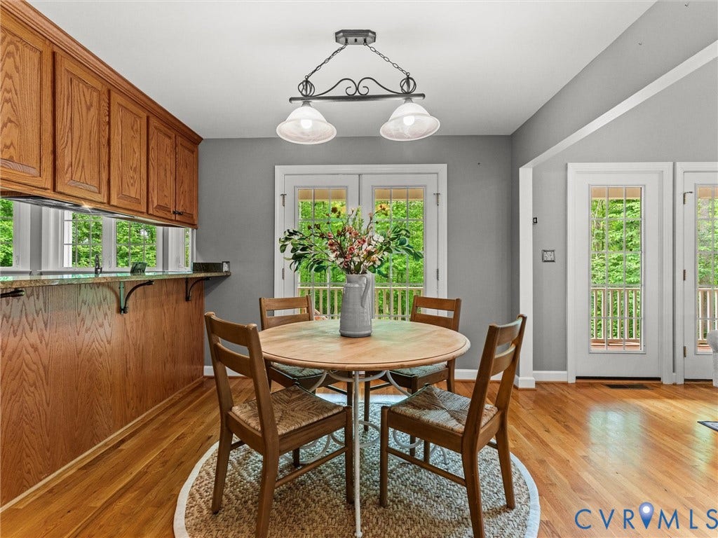 Wood-finish cabinetry, wood-finish flooring, two sets of French doors, and a vaulted ceiling