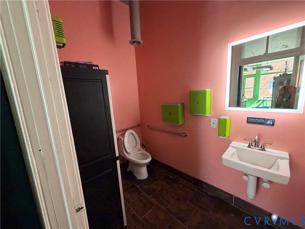 800 W Marshall Street, Richmond, VA 23220 Wall-mounted sink with brushed nickel faucet, illuminated rectangular mirror, and grab bar
