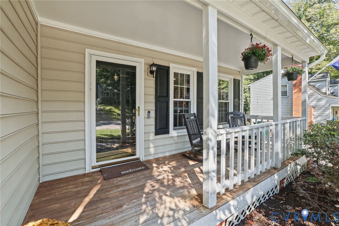 13512 Master Stag Drive, Midlothian, VA 23112 Covered front porch featuring wood-finish decking, white balustrades, horizontal siding, and decorative window shutters
