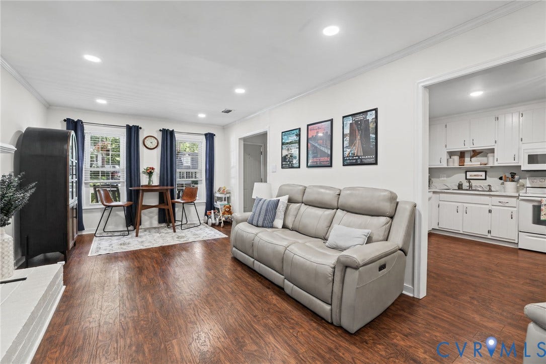13512 Master Stag Drive, Midlothian, VA 23112 Living space featuring wood-finish flooring, recessed lighting, and crown molding, opening to a kitchen equipped with white cabinetry and white appliances