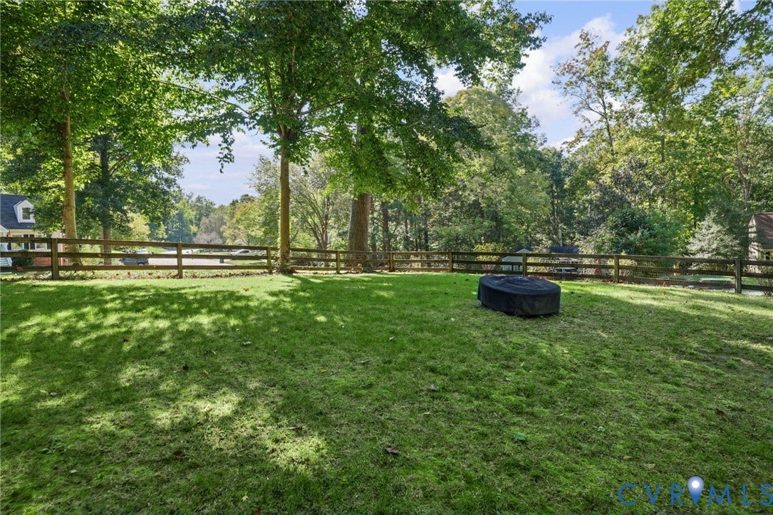 13512 Master Stag Drive, Midlothian, VA 23112 Expansive backyard featuring a manicured lawn, perimeter post-and-rail fencing, and mature trees