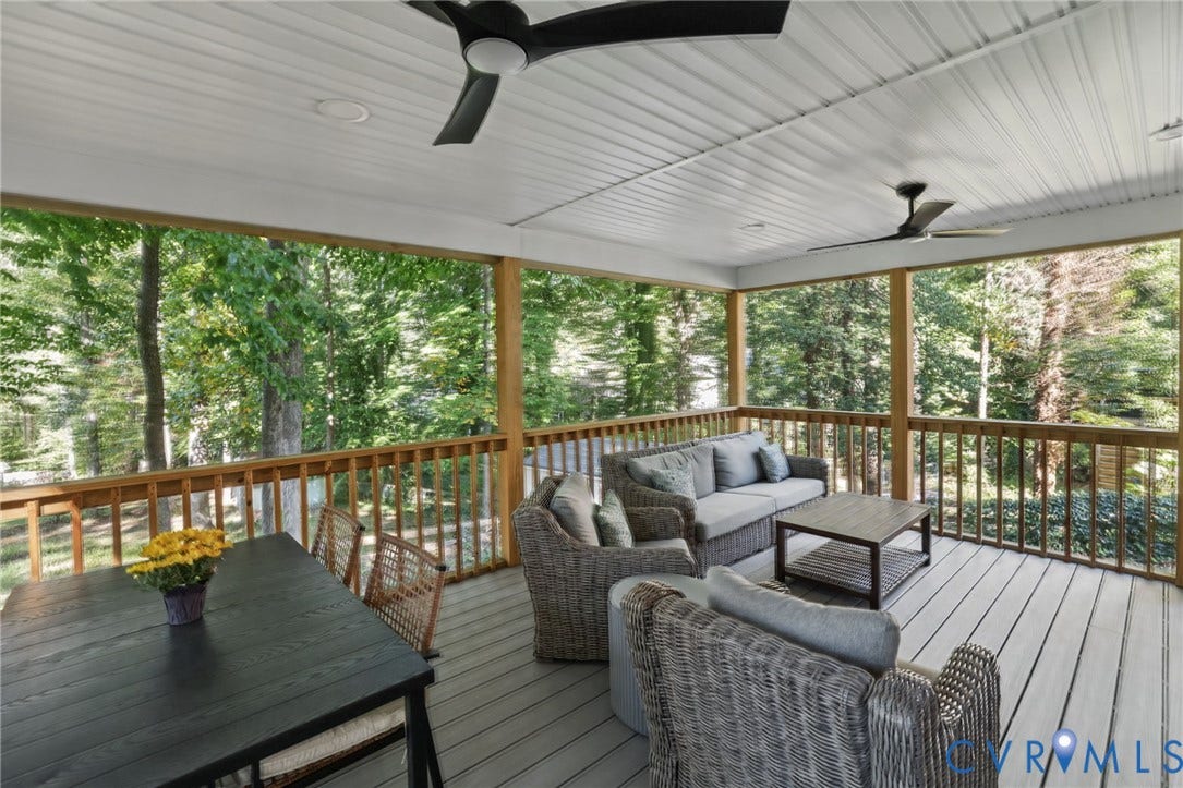 13512 Master Stag Drive, Midlothian, VA 23112 Covered deck featuring wood-finish decking, light-toned beadboard ceiling, dual ceiling fans, and a wood railing overlooking mature trees