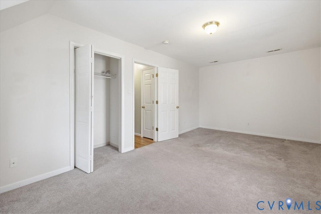 13308 S Chester Road, Chester, VA 23831 Spacious primary suite with neutral carpeting, multiple closet storage options including a walk-in closet, and an ensuite bathroom