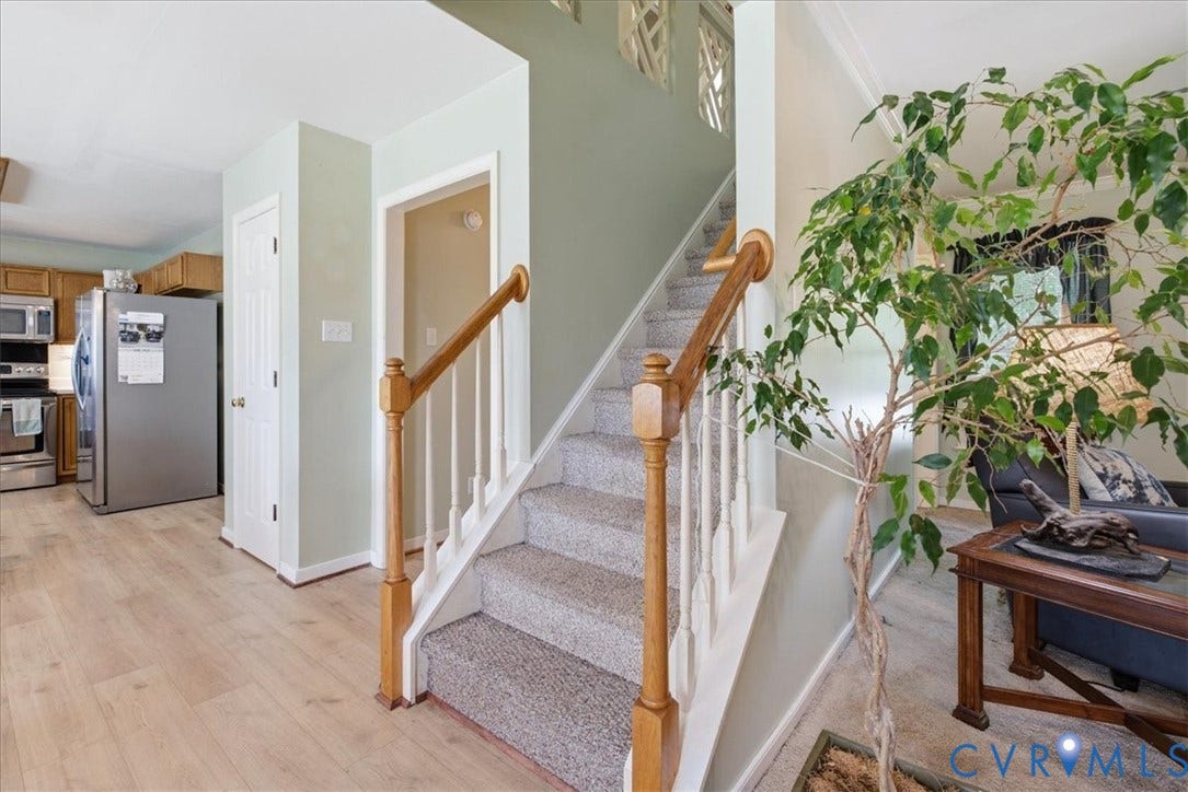 13308 S Chester Road, Chester, VA 23831 Welcoming foyer featuring wood-finish flooring, a prominent staircase with wooden handrails and white balusters, and access to the kitchen