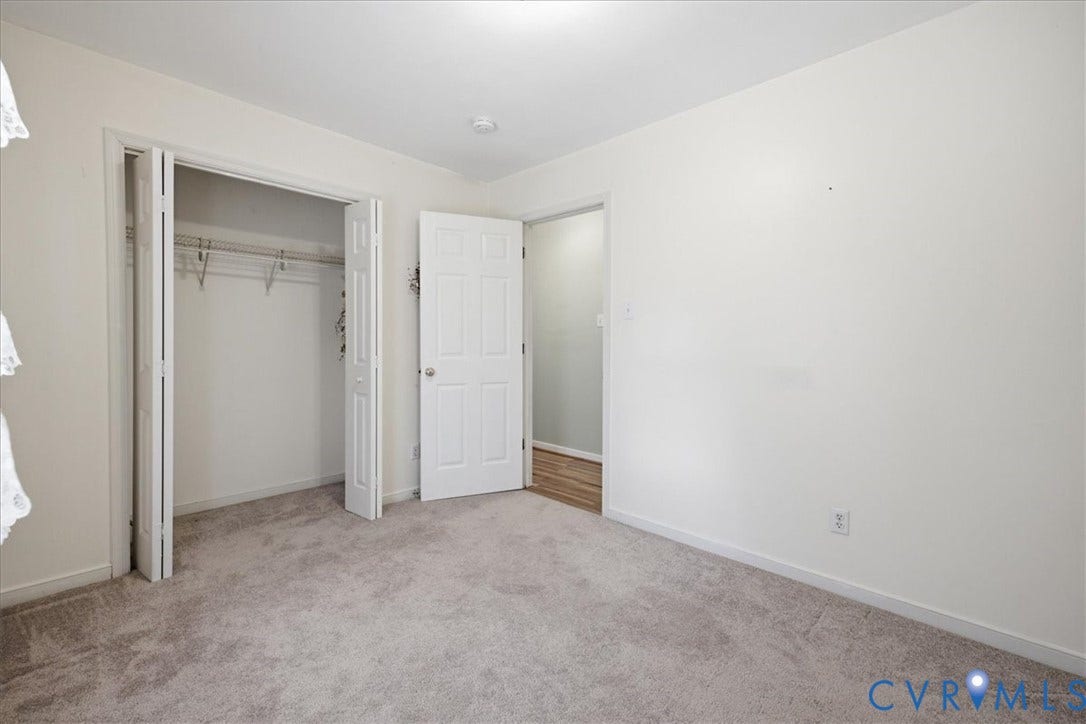 13308 S Chester Road, Chester, VA 23831 Neutral-toned carpeting, white walls, bi-fold closet doors, and an additional white paneled door