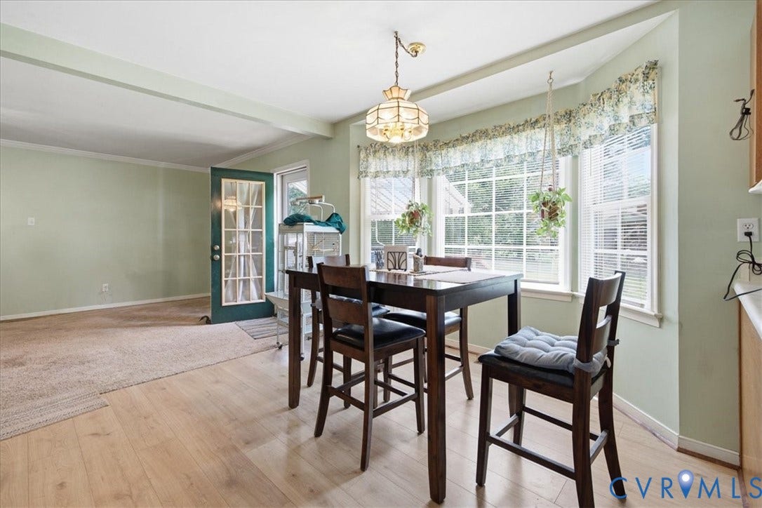 13308 S Chester Road, Chester, VA 23831 Wood-finish flooring, bay window with multiple panes, light-toned walls, and a glass-paneled door