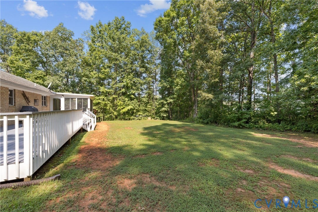 3621 Jefferson Highway, Rual, Mineral, VA 23093 Expansive lawn with mature trees, a screened-in porch, and an extended outdoor deck
