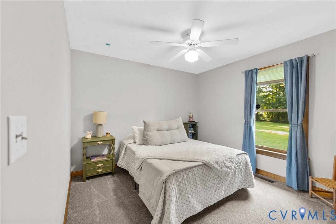 3621 Jefferson Highway, Rual, Mineral, VA 23093 Light gray wall paint, carpeting, ceiling fan with integrated lighting, and a window with wood trim