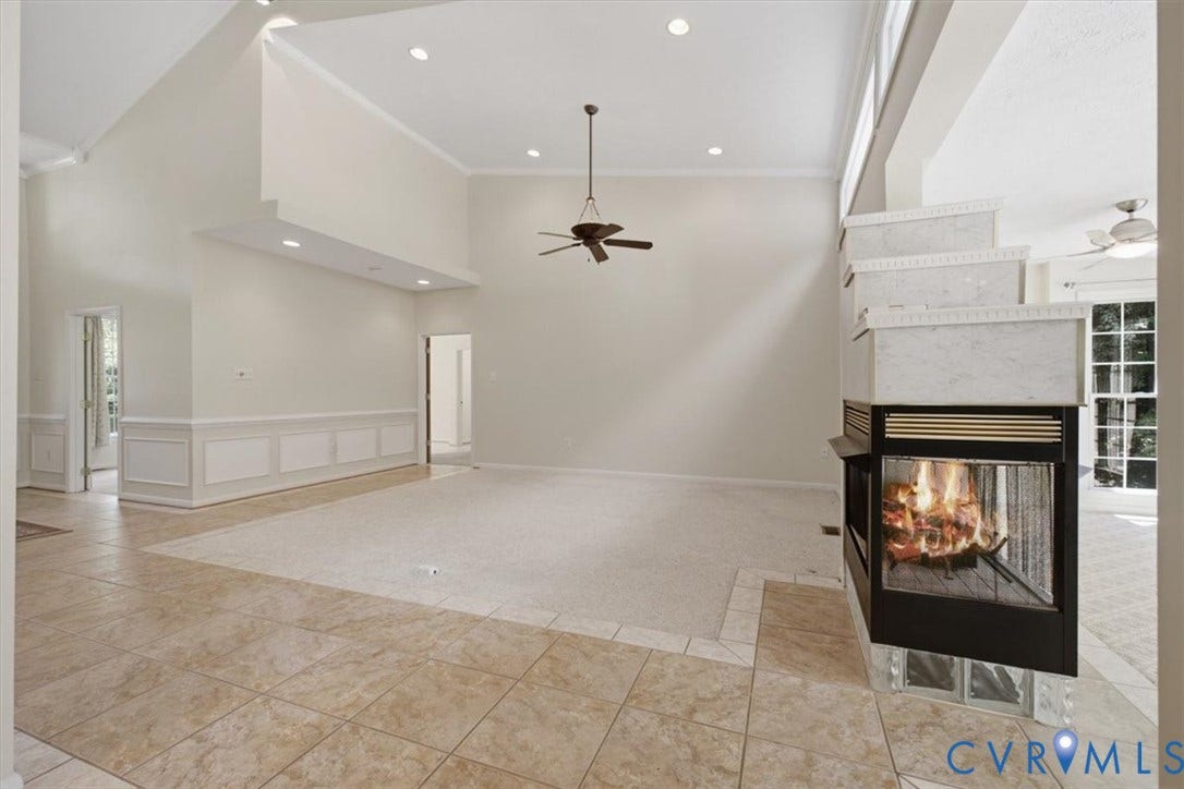 12600 Lilking Road, Chester, VA 23831 Spacious living area featuring a two-sided fireplace with a tiered surround, high vaulted ceilings, recessed lighting, and a ceiling fan