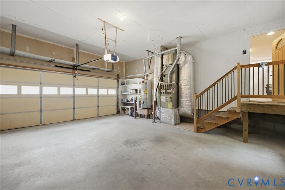 12600 Lilking Road, Chester, VA 23831 Spacious garage featuring a three-panel sectional door with frosted glass panels, polished concrete flooring, and integrated HVAC and water heater systems
