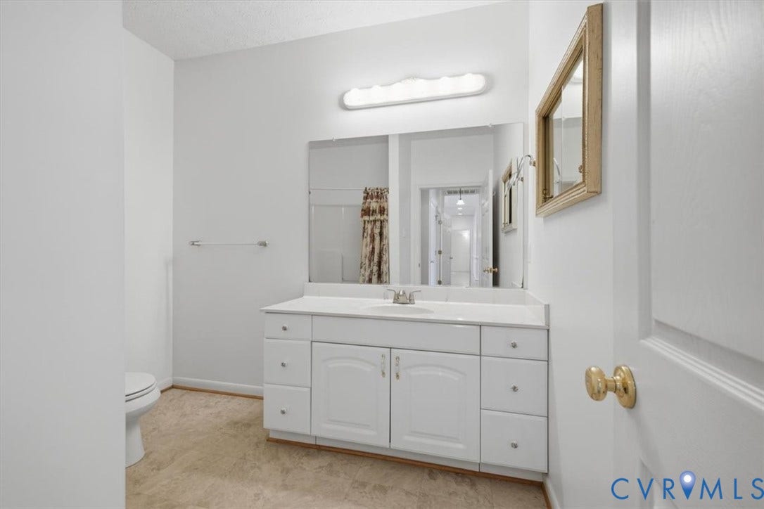 12600 Lilking Road, Chester, VA 23831 White vanity with a single sink, large wall-mounted mirror, and overhead strip lighting