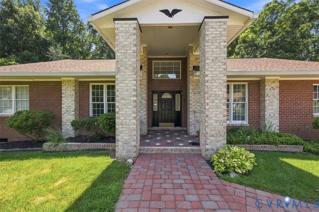 12600 Lilking Road, Chester, VA 23831 Welcoming brick and stone facade featuring a centered entrance with dark wood doors, flanked by substantial stone columns and topped with a peaked portico