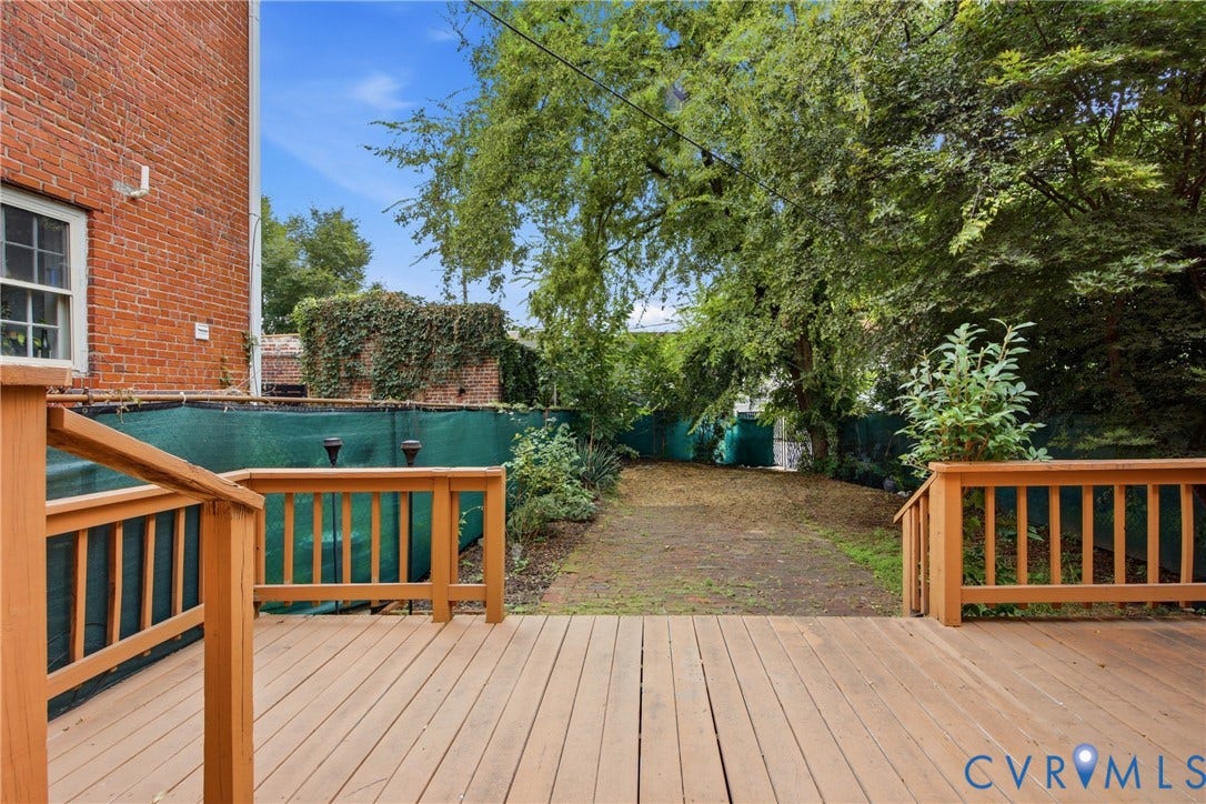 209 W Clay Street, Jackson Ward, Richmond, VA 23220 Spacious wood-finish deck with wood railings, leading to a landscaped yard with mature trees