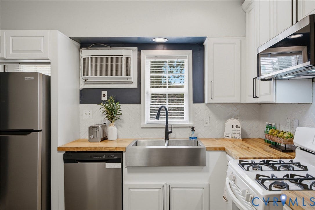 209 W Clay Street, Jackson Ward, Richmond, VA 23220 Kitchen featuring white cabinetry, butcher block countertops, stainless steel appliances, a farmhouse sink with a gooseneck faucet, and a white tile backsplash