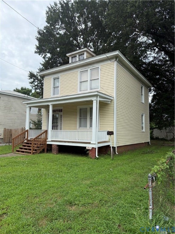 1313 Enfield Avenue, Richmond, VA 23224 Two-story residence featuring light-colored siding, a covered porch with white railings, and a dormer window