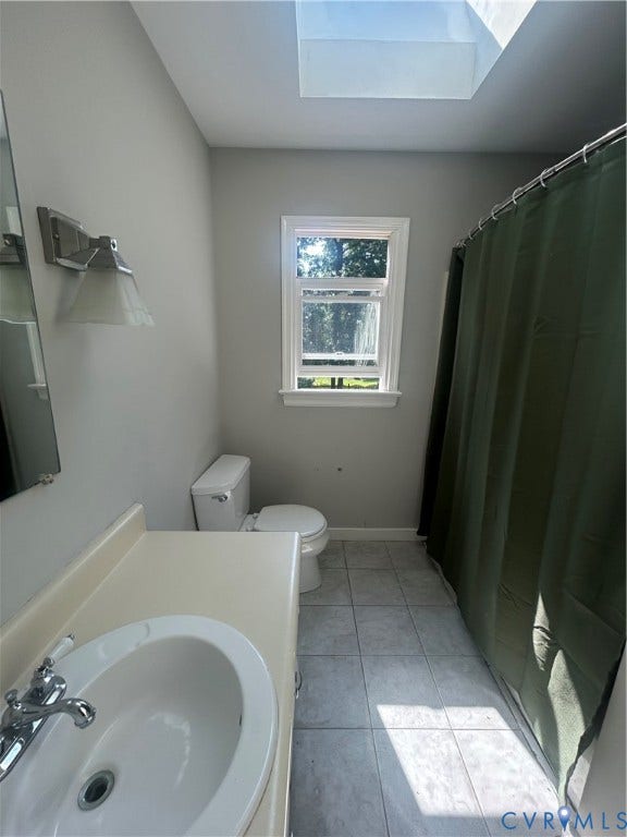 10641 Cliffmore Drive, Glen Allen, VA 23060 Skylight for ambient illumination, single vanity with integrated sink, chrome faucet, wall-mounted light fixture, and tiled flooring