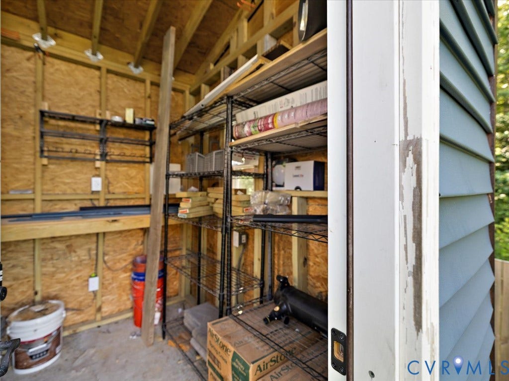 Storage structure with exposed wood framing, sloped ceiling, and built-in shelving units