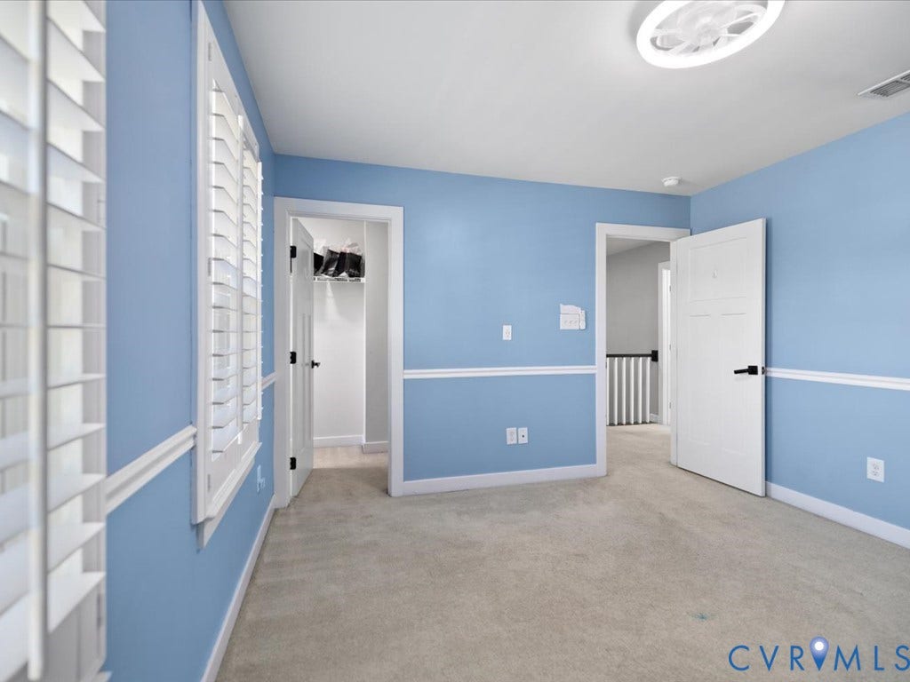 Planted shutters, wall molding, neutral carpet flooring, and a contemporary flush-mount light fixture