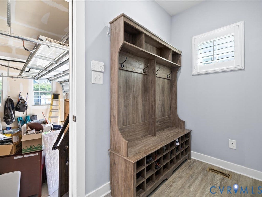 Wood-finish mudroom built-in with integrated bench seating, cubby storage, and coat hooks