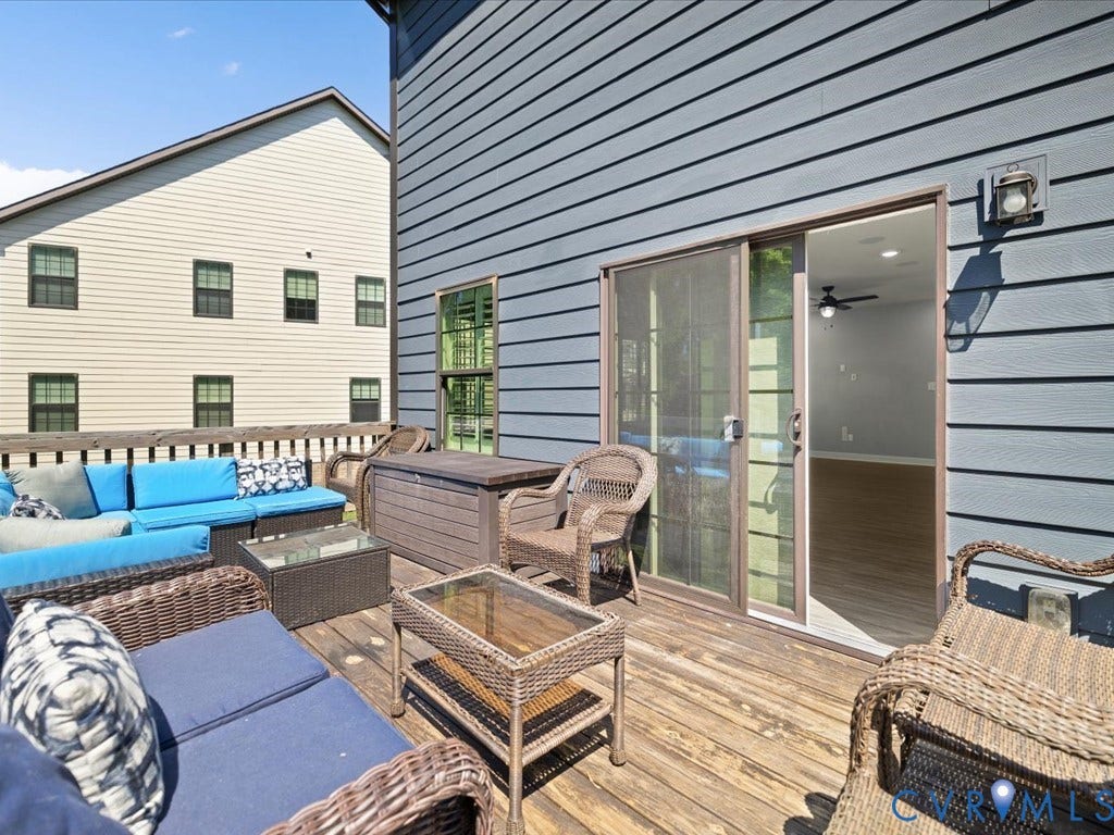 Expansive wood deck with a privacy railing, featuring direct access to the interior via a glass sliding door