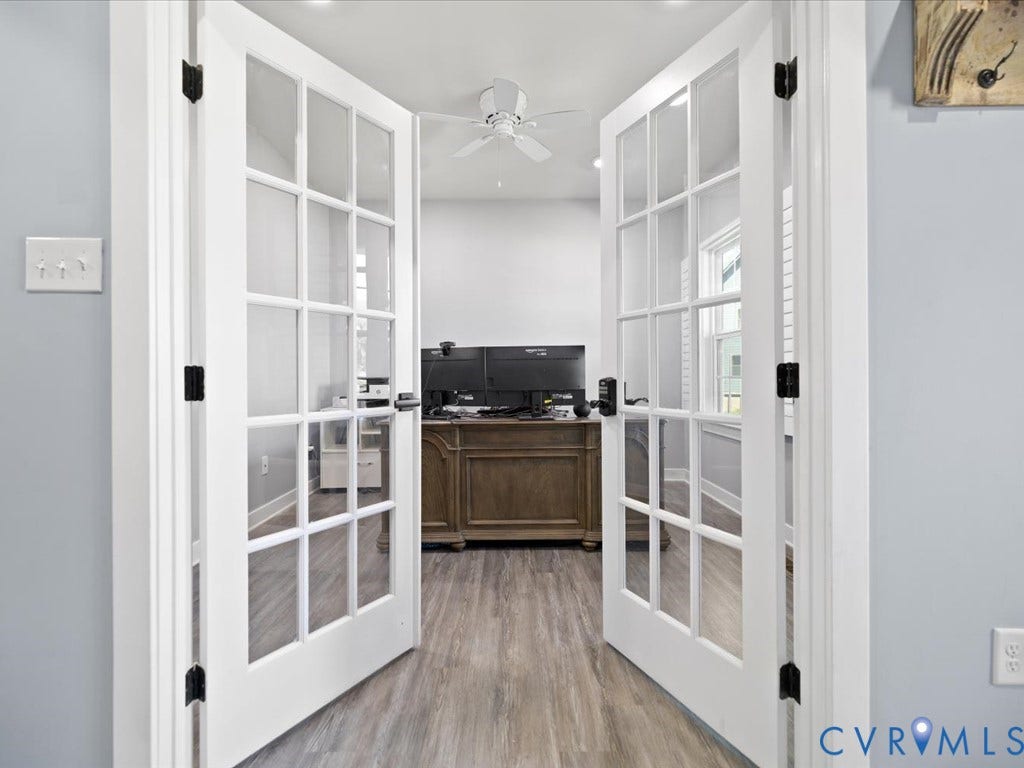 Double French doors with glass panels, wood-finish flooring, ceiling fan, and white trim