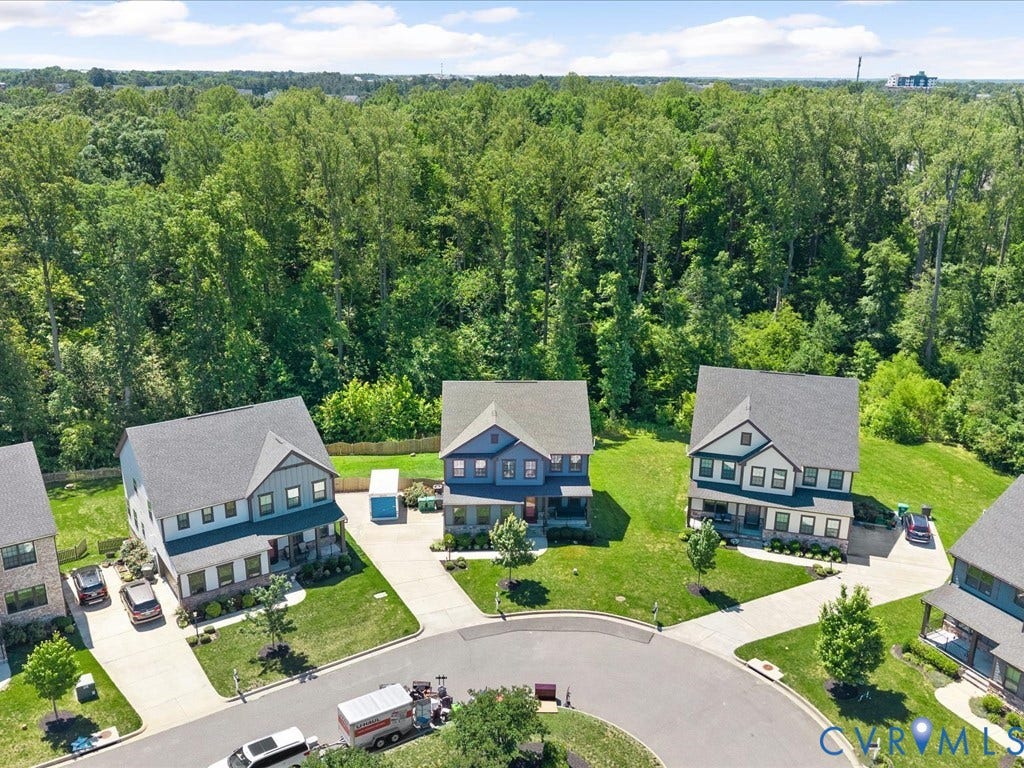 Neighborhood setting with established residential properties and natural tree lines