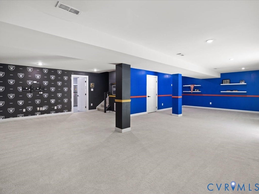 Expansive room featuring light gray carpeting, recessed lighting, and built-in shelving
