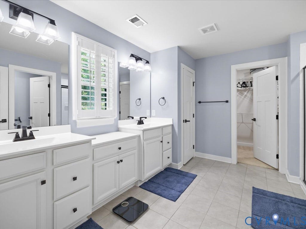 Dual vanities with white cabinetry, matte black fixtures, and integrated sinks