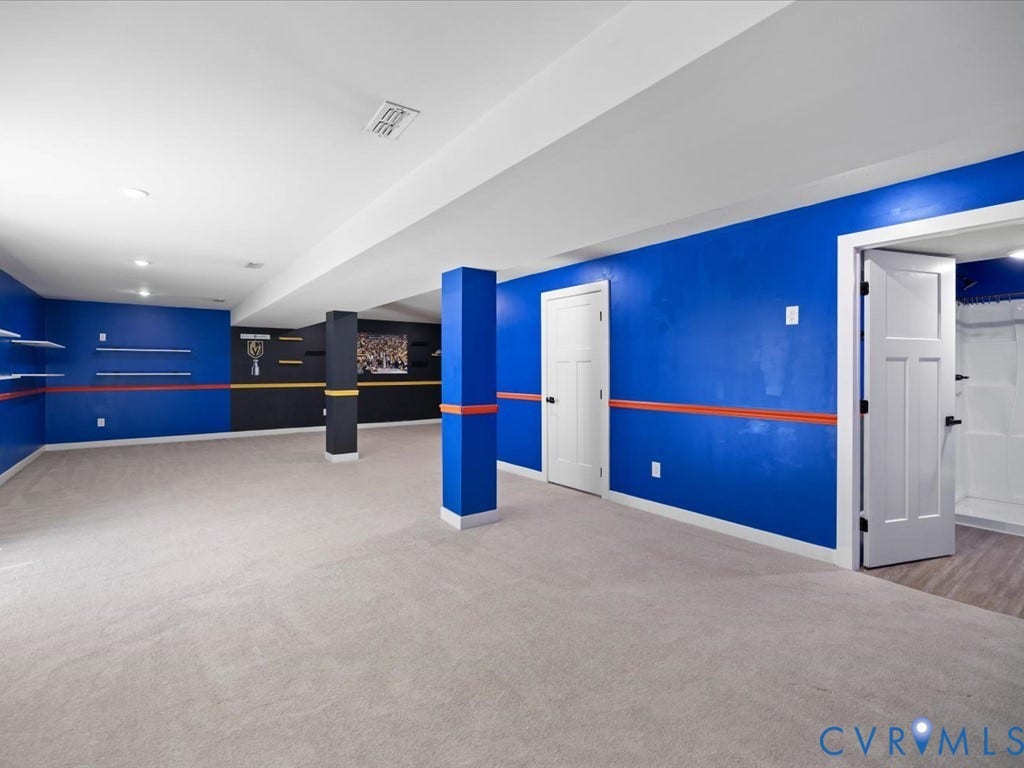 Spacious room featuring carpeting, recessed lighting, built-in shelving, and two paneled doors