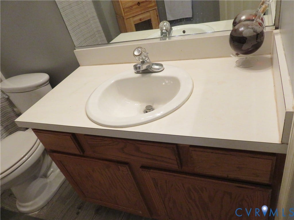 3107 McCabe Court, Chester, VA 23831 Upstairs bathroom. Vanity featuring a built-in sink, laminate countertop, and wood-finish cabinetry