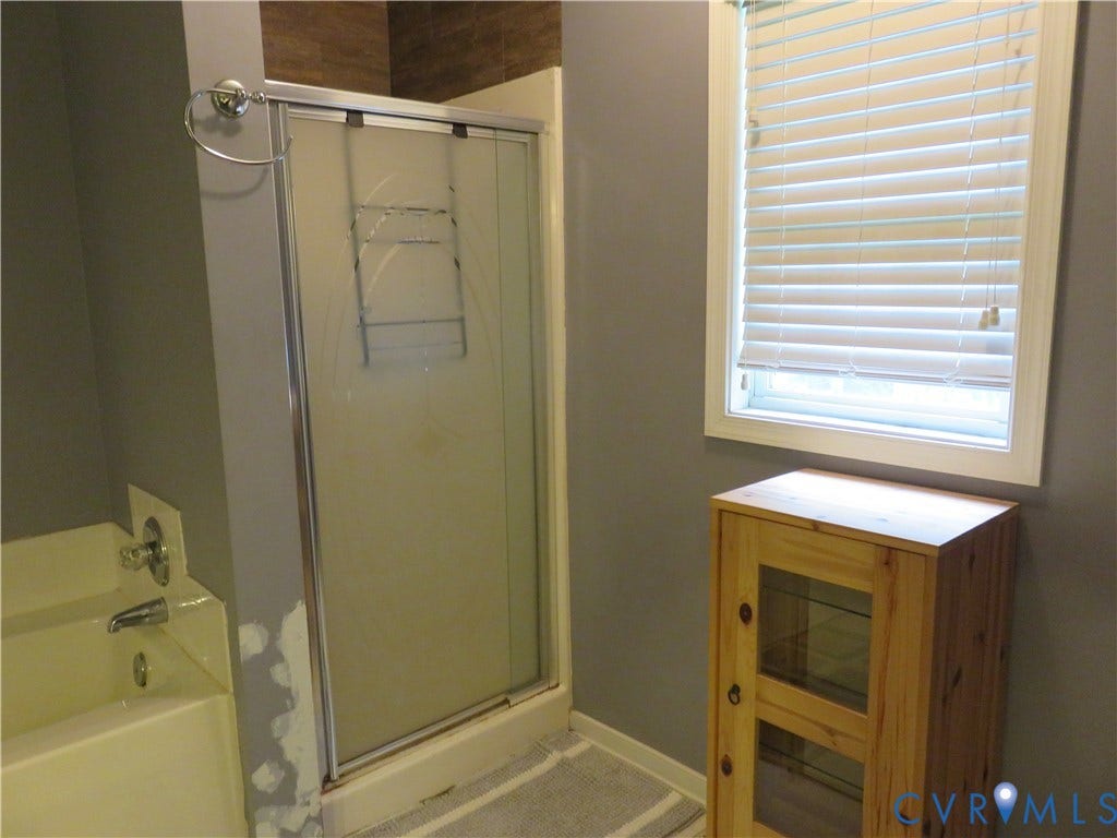 3107 McCabe Court, Chester, VA 23831 Shower enclosure with sliding frosted glass doors, chrome hardware, and a built-in bathtub