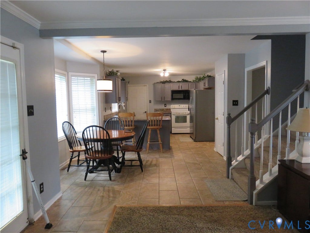 3107 McCabe Court, Chester, VA 23831 Tile flooring throughout, kitchen with grey cabinetry, built-in microwave, white electric range, and a bay window