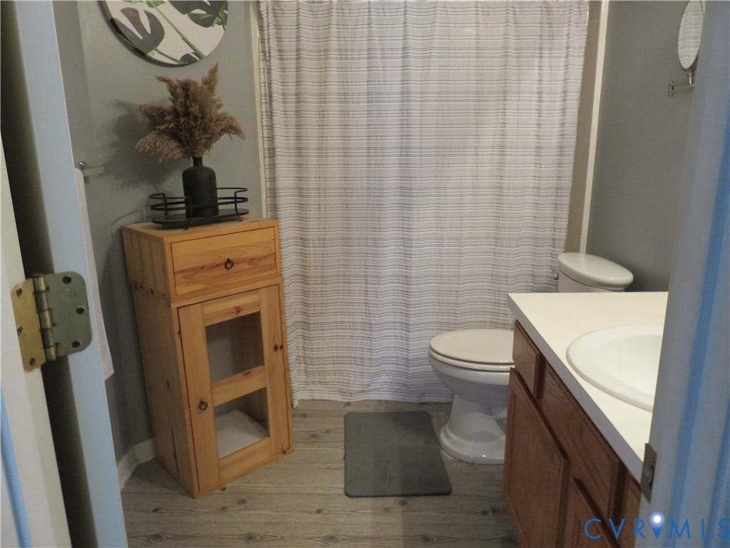 3107 McCabe Court, Chester, VA 23831 Upstairs hall bathroom. Wood-finish flooring with a white vanity and integrated sink
