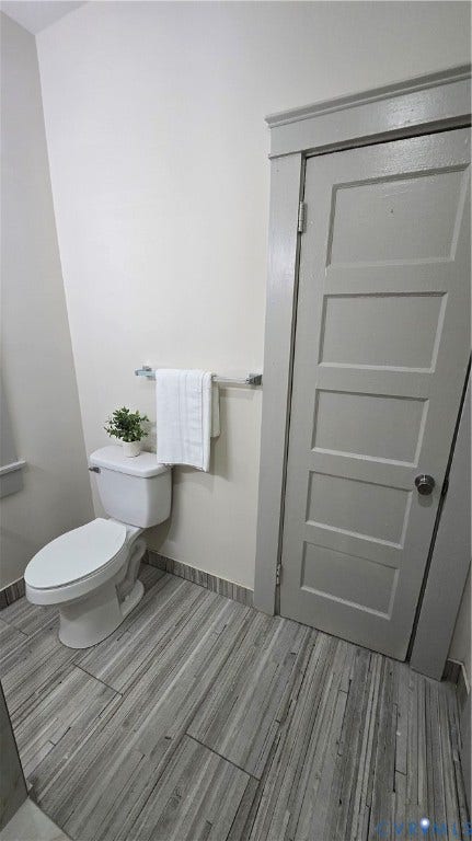 2317 5th Avenue, Richmond, VA 23222 Wood-finish tile flooring complemented by a white commode and matching baseboard trim