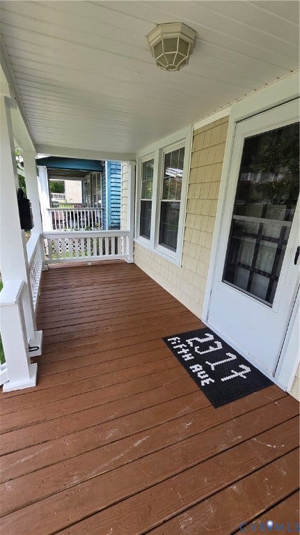 2317 5th Avenue, Richmond, VA 23222 Covered front porch featuring wood plank flooring, white railing, and decorative ceiling light fixture