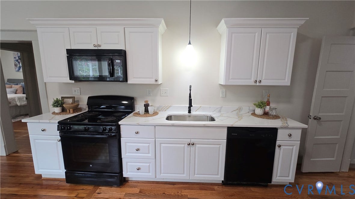 2317 5th Avenue, Richmond, VA 23222 White cabinetry with crown molding, integrated microwave, black range, stainless steel sink with black faucet, and a black dishwasher